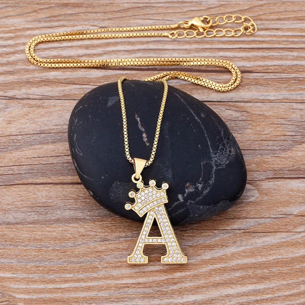 Gold necklace with a letter 'A' pendant on a dark stone surface