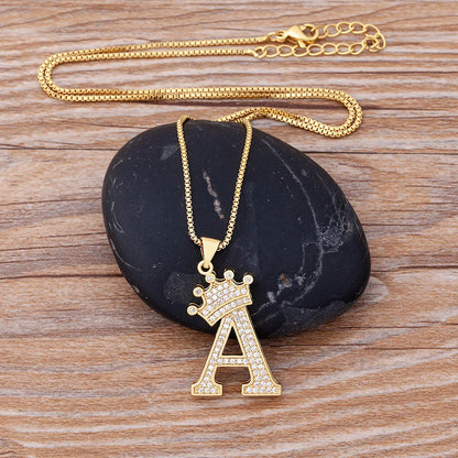 Gold necklace with a letter 'A' pendant on a dark stone surface