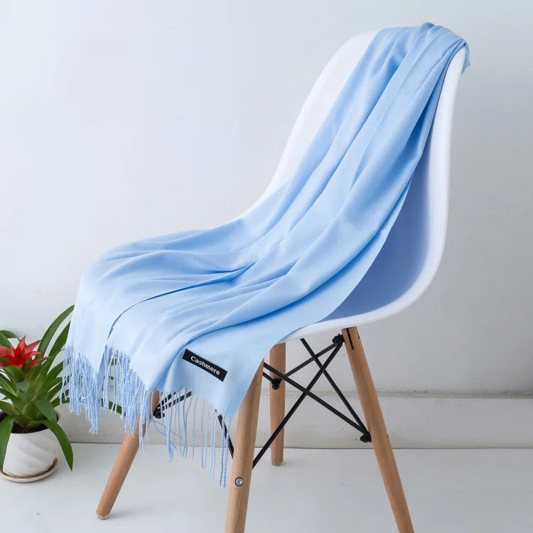 Light blue scarf draped over a white chair with a plant in the background