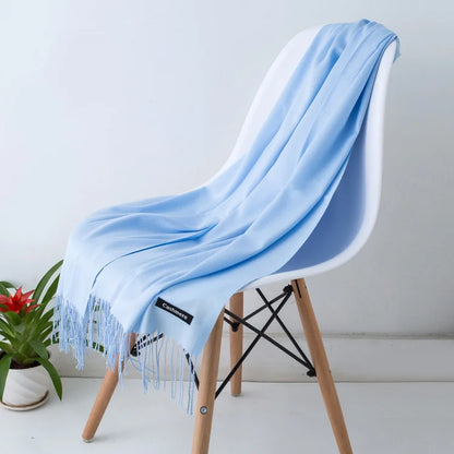 Light blue scarf draped over a white chair with a plant in the background