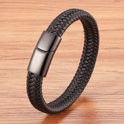 Black braided bracelet with a metallic clasp on a wooden surface