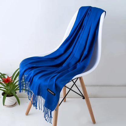 Blue scarf draped over a white chair with a plant in the background
