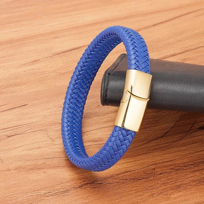 Blue braided bracelet with a gold clasp on a wooden surface