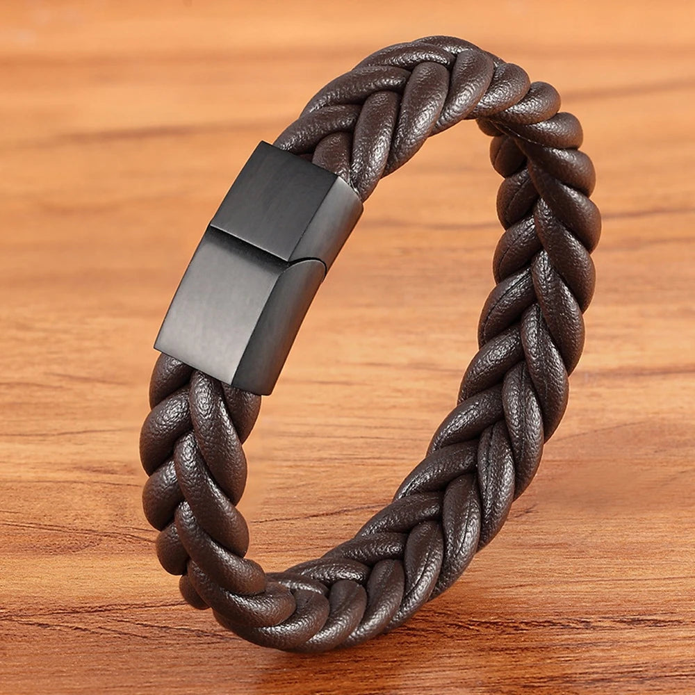 Brown braided leather bracelet with a black clasp on a wooden surface