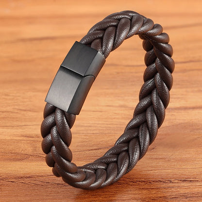 Brown braided leather bracelet with a black clasp on a wooden surface
