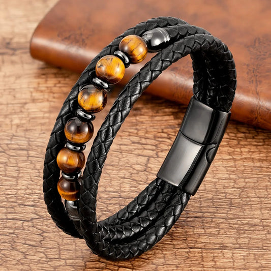 Black braided leather bracelet with brown beaded accents on a wooden surface