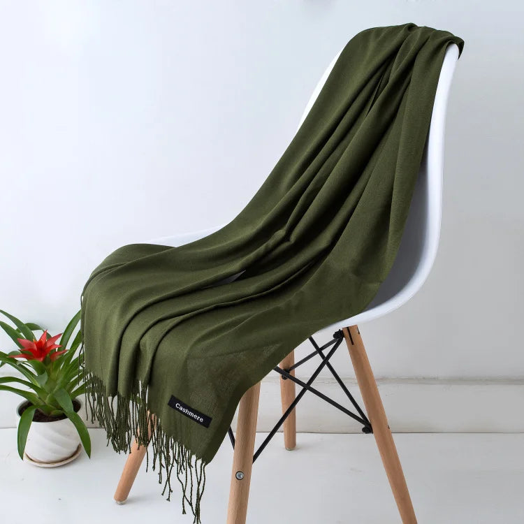 Green scarf draped over a white chair with a plant in the background