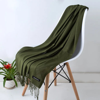 Green scarf draped over a white chair with a plant in the background