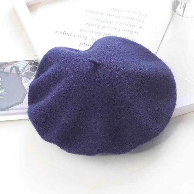 Navy blue beret on a white surface with a magazine underneath
