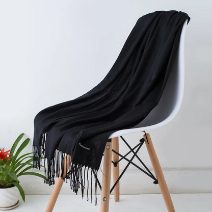 Black scarf draped over a white chair with wooden legs on a light background