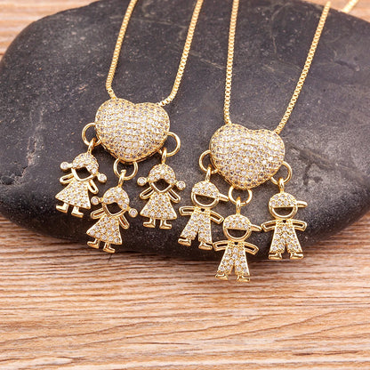Gold necklaces with heart and figure pendants on a stone surface