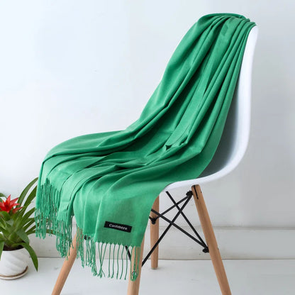 Green scarf draped over a white chair with a plant in the background