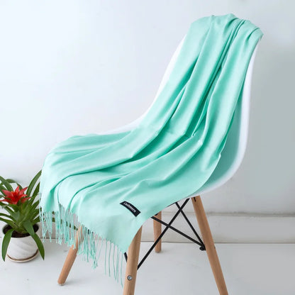 Mint green scarf draped over a chair with a white background