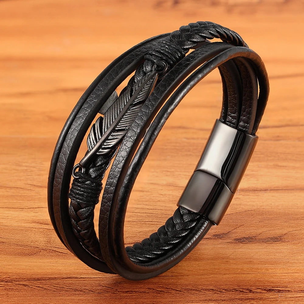 Black braided leather bracelet with feather design on a wooden surface