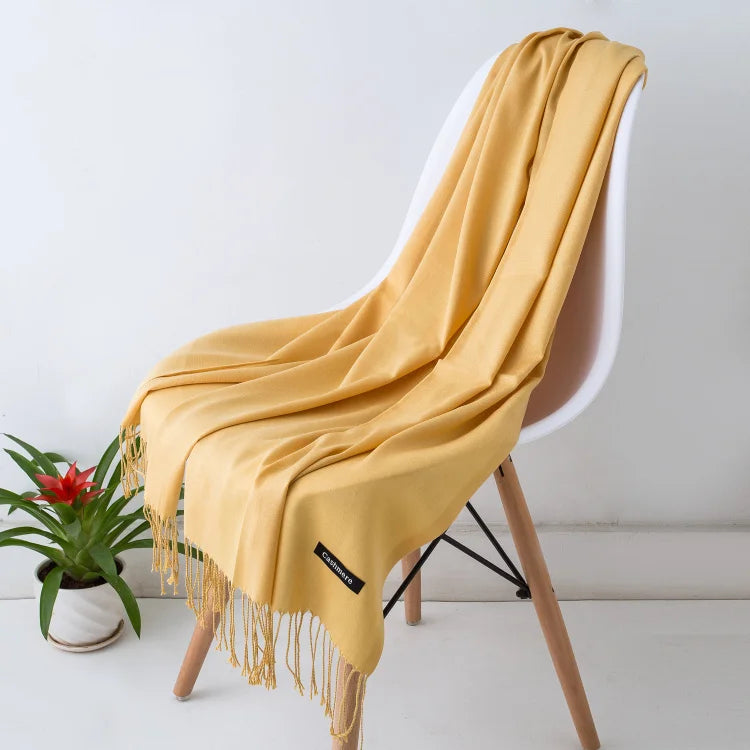 Yellow scarf draped over a chair with a plant in the background