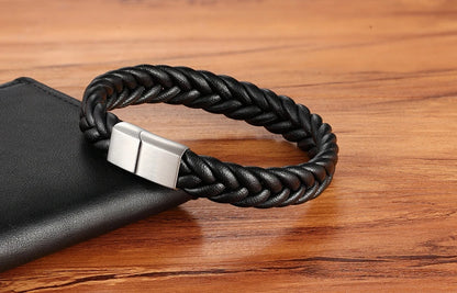 Black braided bracelet with a silver clasp on a wooden surface