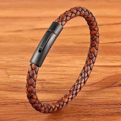 Brown braided leather bracelet with black clasp on a wooden surface
