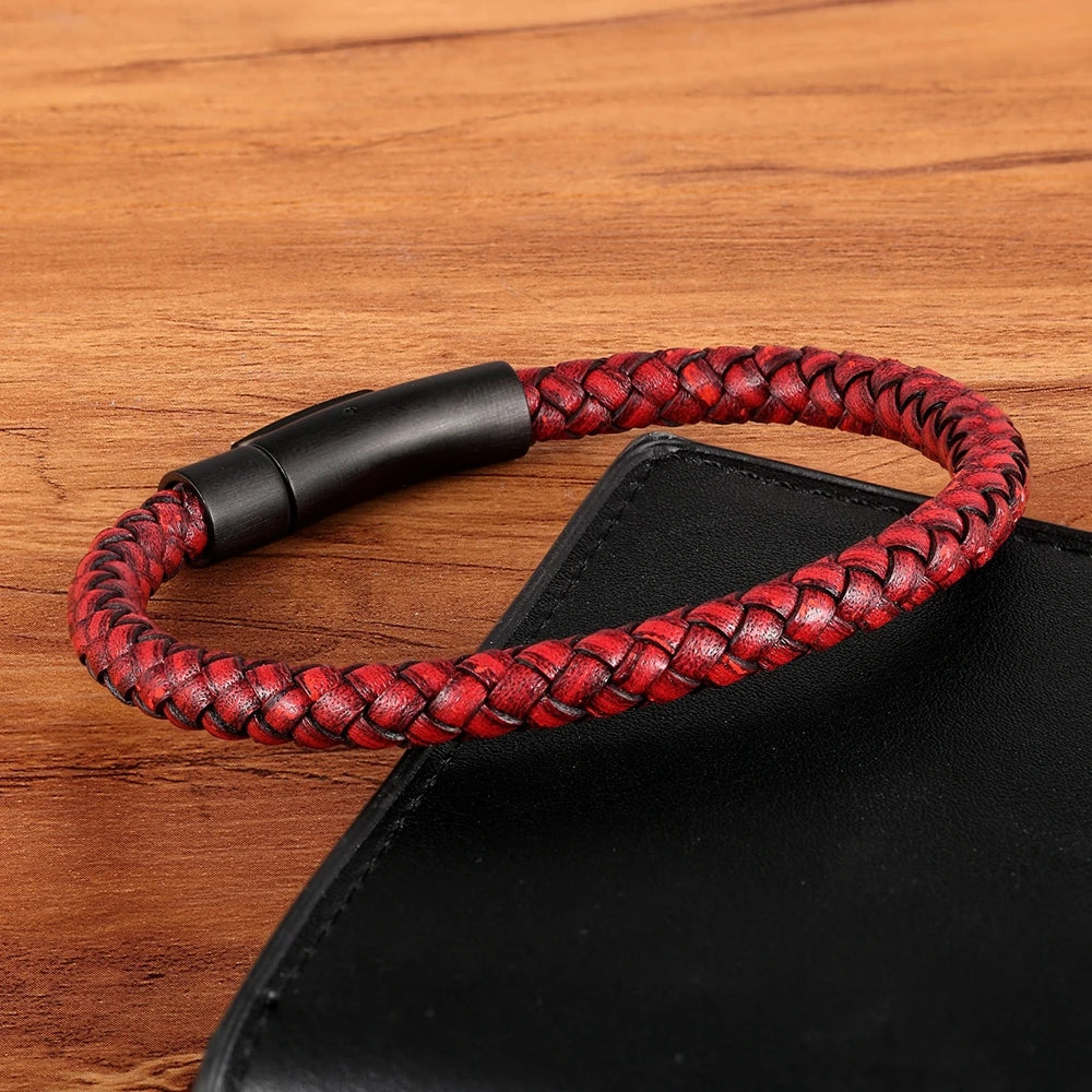 Red braided leather bracelet with black clasp on a wooden surface