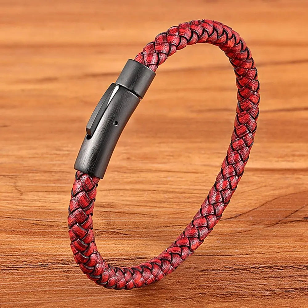 Red braided bracelet with a black clasp on a wooden surface