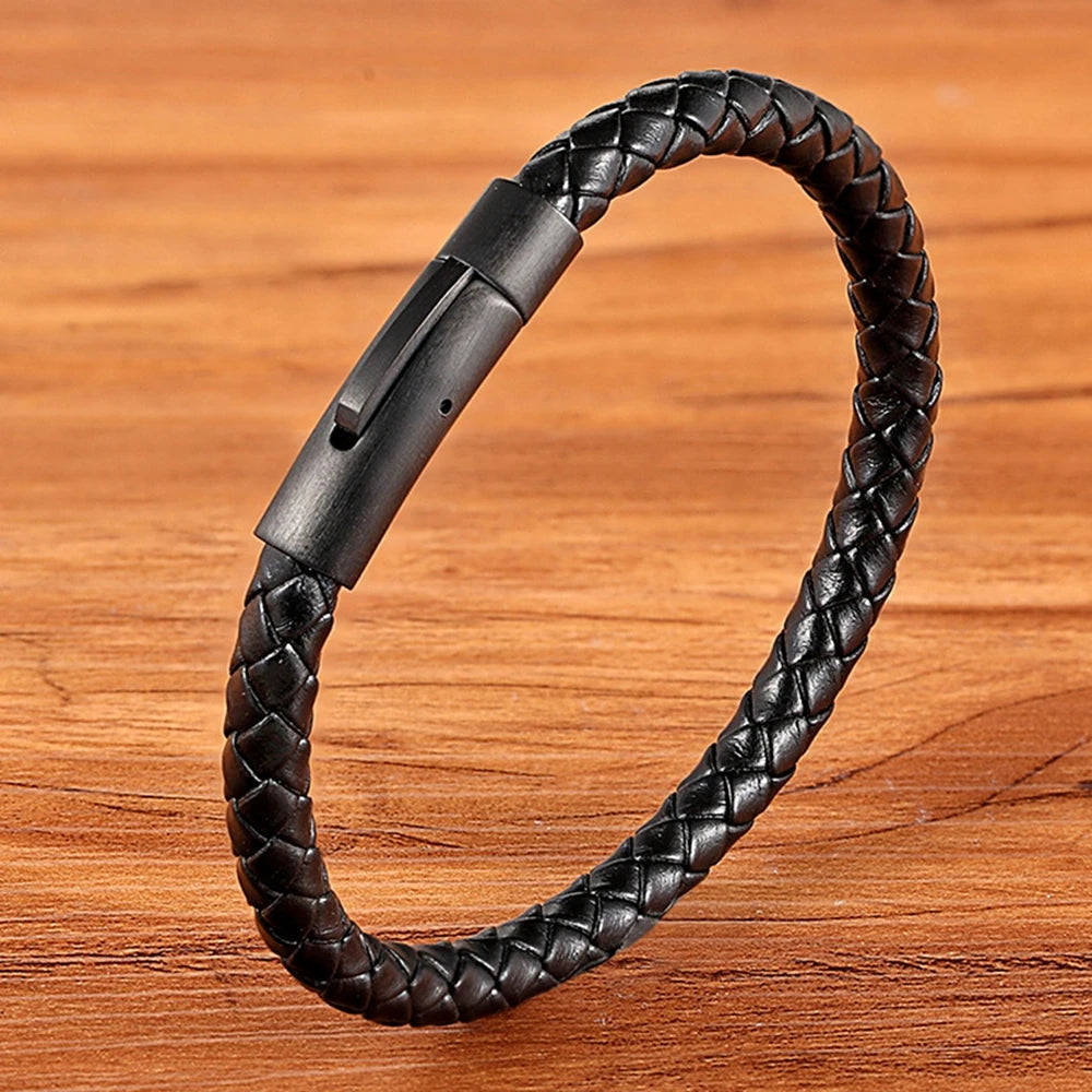 Black braided leather bracelet on a wooden surface