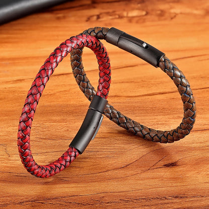 Braided red and brown leather bracelets with black metal clasp on a wooden surface