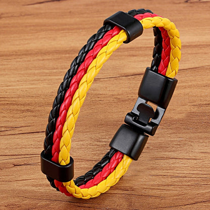 Bracelet with red, yellow, and black braided design on a wooden surface