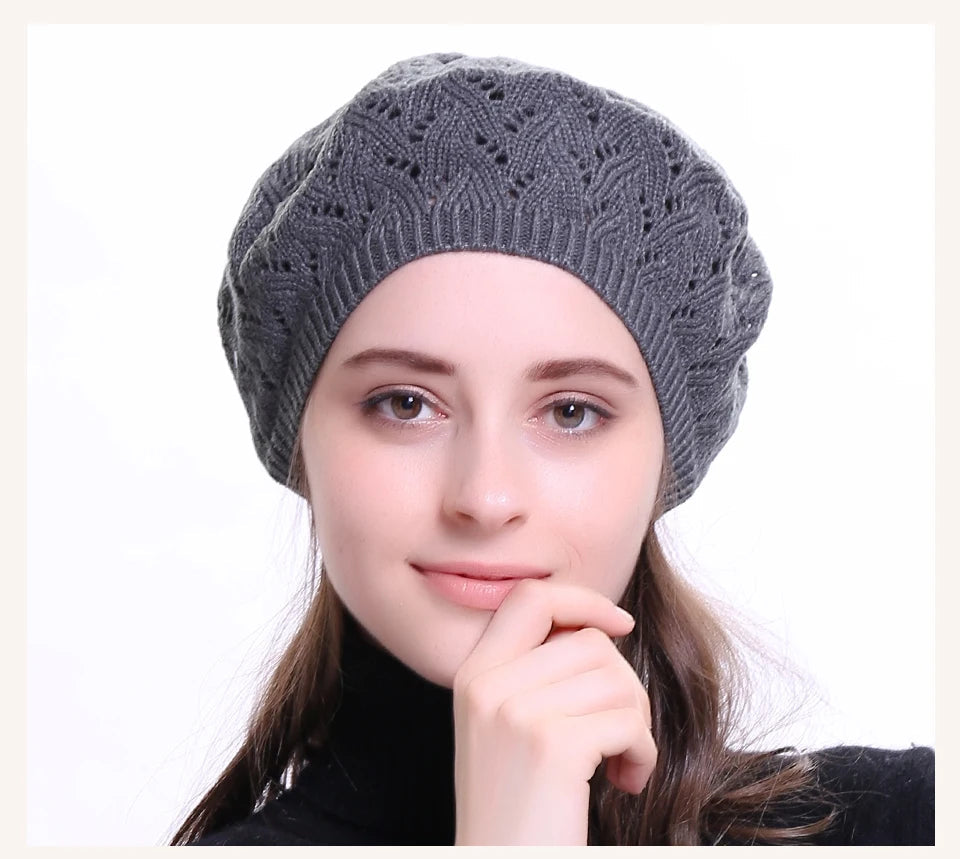 Woman wearing a dark grey knit beanie on a white background