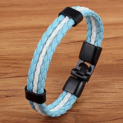 Braided blue and white bracelet with black clasp on a wooden surface