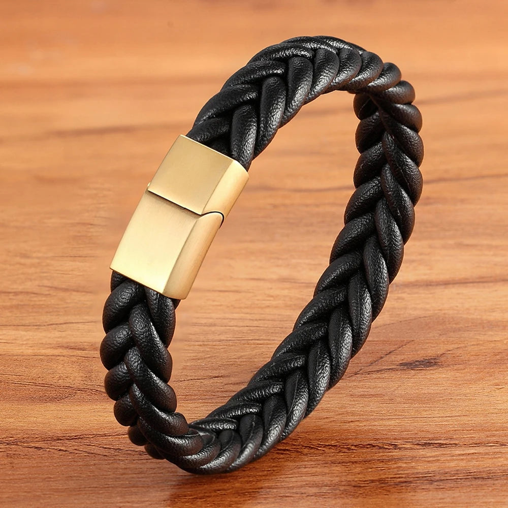 Black braided leather bracelet with a gold clasp on a wooden surface