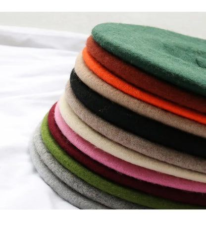 Stack of colourful beret hats on a white background