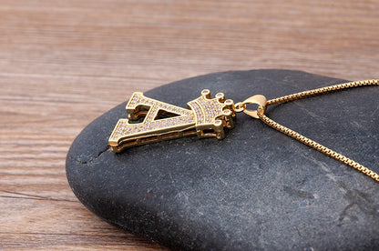 Gold necklace with a unique pendant on a dark stone surface