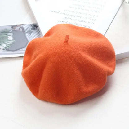 Orange beret on a white surface with a magazine in the background