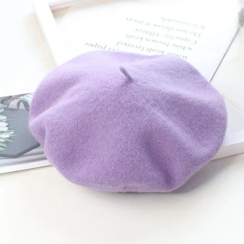 Purple beret on a white surface with a magazine underneath