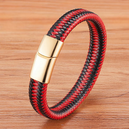 Red and black braided bracelet with a gold clasp on a wooden surface