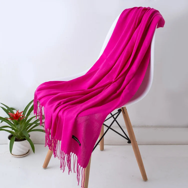 Pink scarf draped over a white chair with a plant in the background