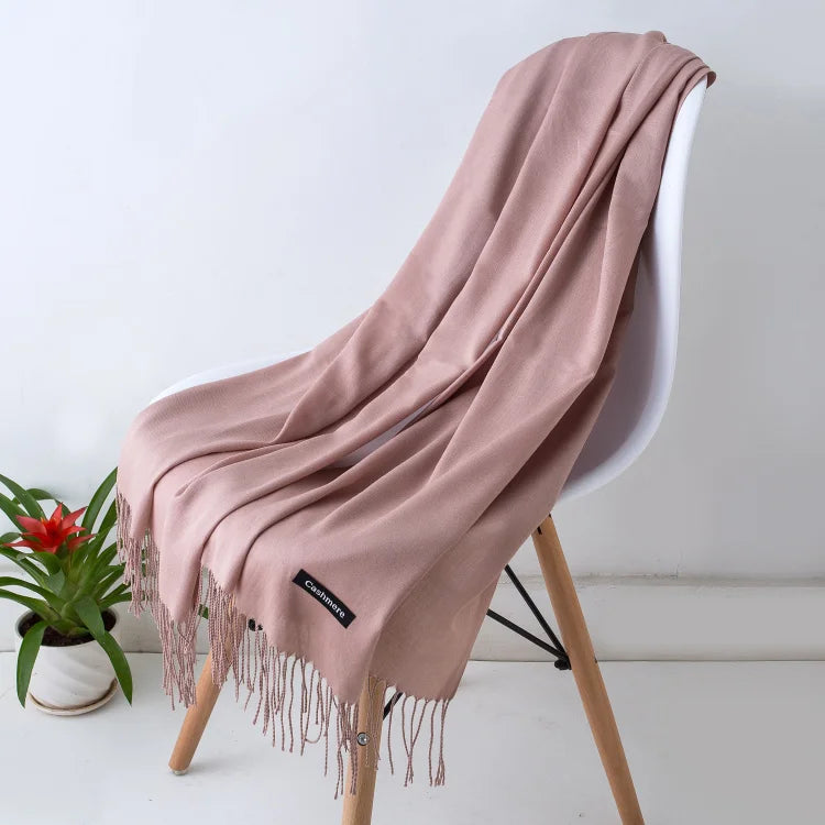 Pink scarf draped over a chair with a plant in the background