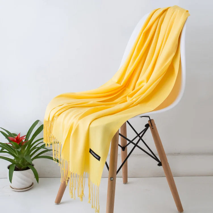 Yellow scarf draped over a white chair with a plant in the background