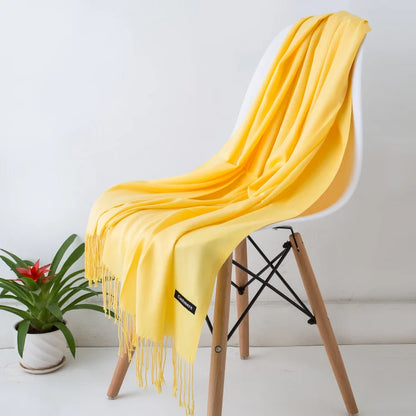 Yellow scarf draped over a white chair with a plant in the background