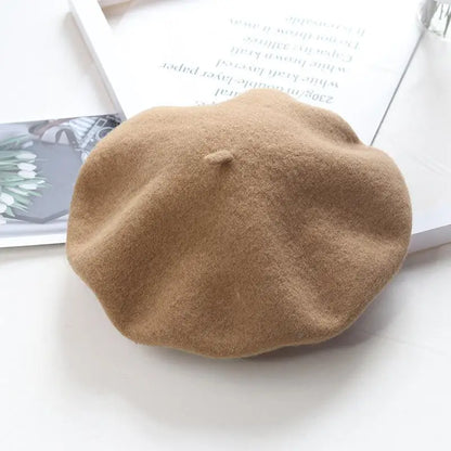 Khaki beret on a white surface with a magazine in the background