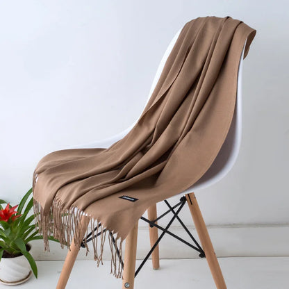 Brown scarf draped over a white chair with a plant in the background
