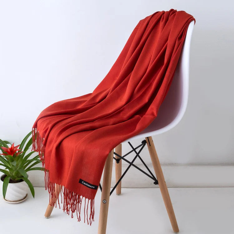 Red scarf draped over a white chair with a plant in the background
