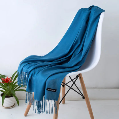 Blue scarf draped over a white chair with a plant in the background