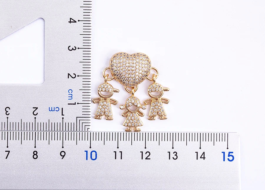 Jewelry charm with heart and child charms on a ruler for scale