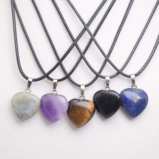Five heart-shaped stone pendants on black cords against a white background