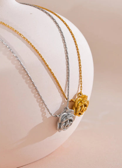 Two necklaces with pendants on a white stand
