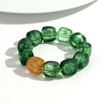 Green beaded bracelet with a gold accent on a white background