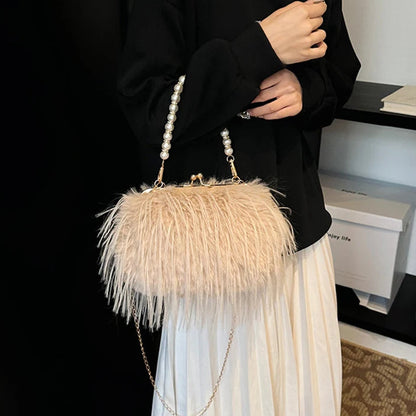 Person holding a beige feathered handbag with pearl handle