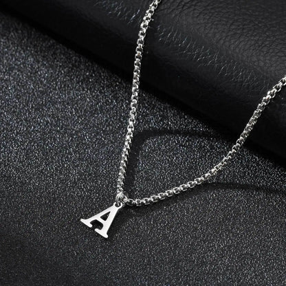 Silver necklace with a 'A' pendant on a dark textured surface