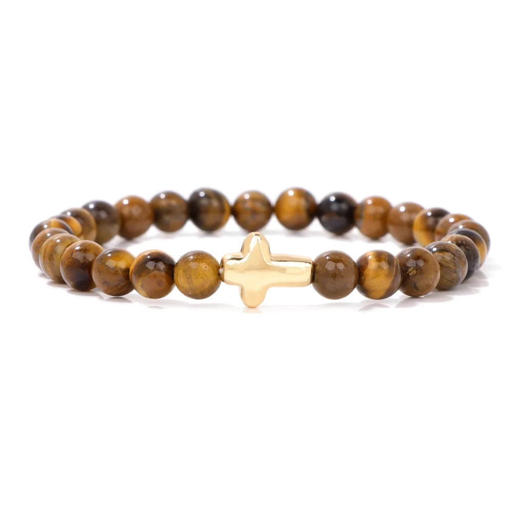 Bracelet with brown beaded design and gold cross charm on a white background