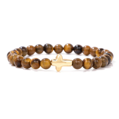 Bracelet with brown beaded design and gold cross charm on a white background